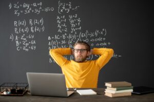 Young teacher or student looking at laptop display during online algebra lesson